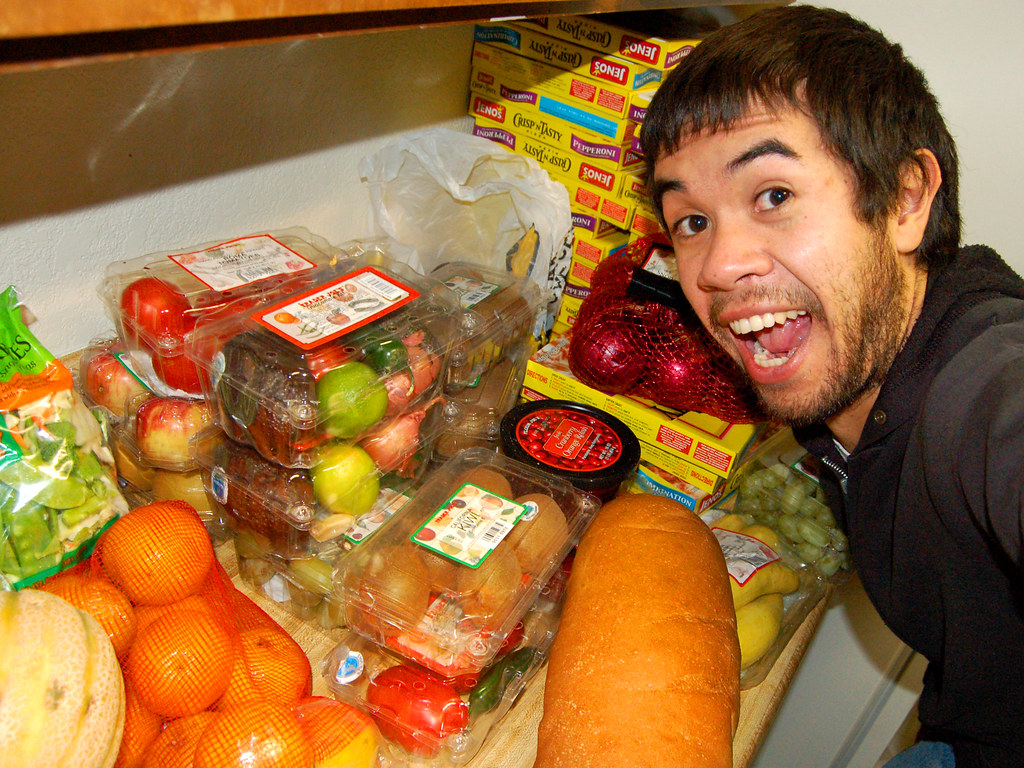 Avocados, bananas, and onions displayed together in a grocery store produce section
