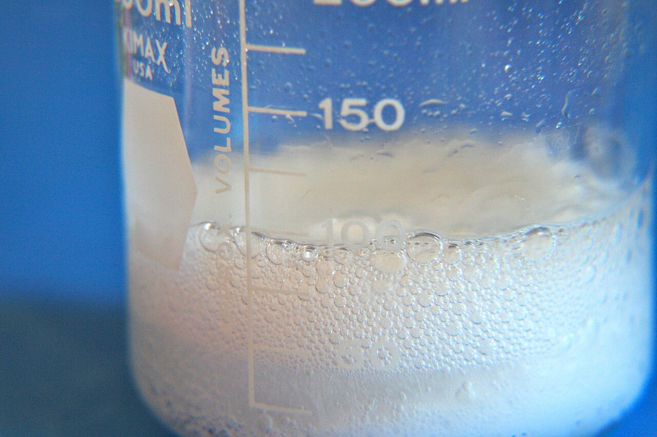 Baking soda and vinegar fizzing together in a bowl demonstrating the chemical reaction