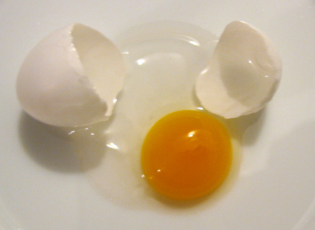 Cracked eggs showing deep orange yolks from well-fed hens