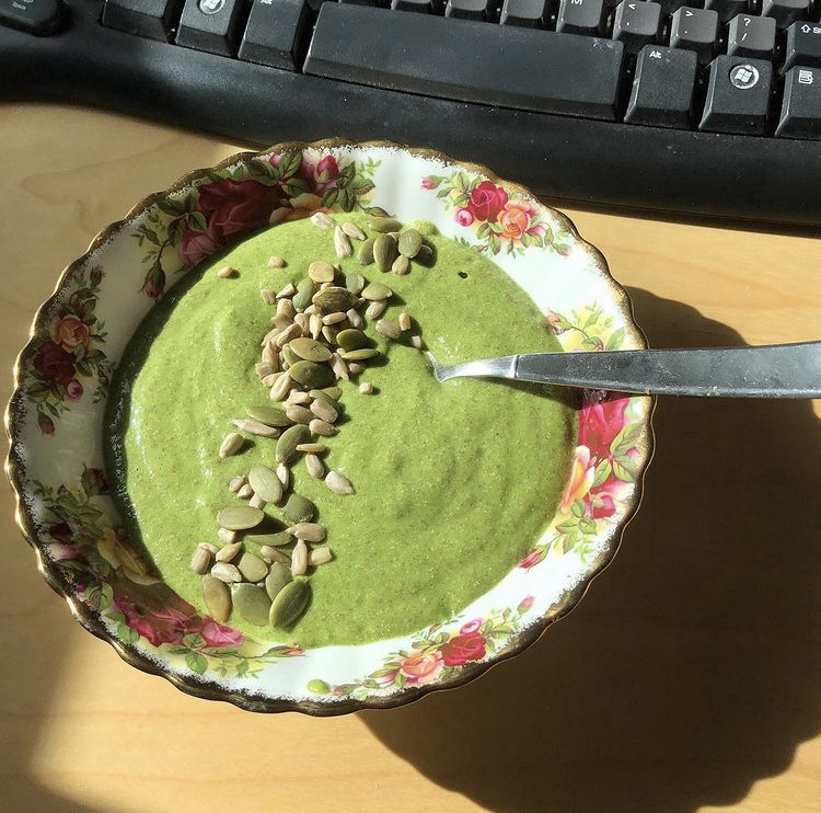 Vibrant green smoothie bowl topped with kiwi and coconut flakes
